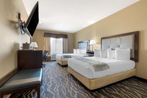Cette chambre comprend deux lits et une télévision. dans l'établissement Best Western Plus Fort Stockton Hotel, à Fort Stockton
