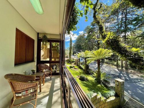 una casa con balcón con vistas al jardín en Apartamentos GRUNENBERG a 5 min do CENTRO by Achei Gramado, en Gramado