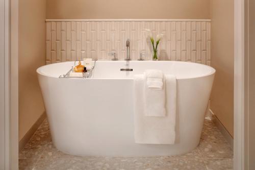 a white bath tub in a bathroom with towels at Fairmont Scottsdale Princess in Scottsdale