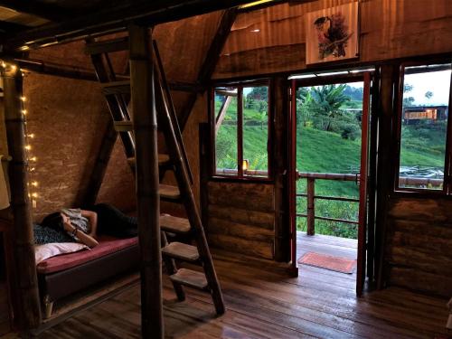 a woman laying on a bed in a tiny house at Cántaros Glamping in Santa Rosa de Cabal