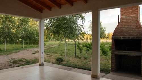 porche con chimenea de ladrillo y vistas a un campo en Departamento Parras del Abuelo 2 en Malargüe