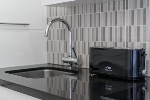 a kitchen counter with a sink and a microwave at BuenaVista Lago La Arena in Puerto de Santiago