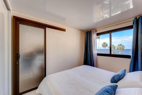 a bedroom with a bed and a window with the ocean at BuenaVista Lago La Arena in Puerto de Santiago