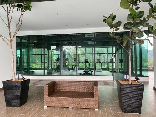 a lobby with a bench and trees in a building at Sunway City Onsen COSY HOME Tambun Ipoh in Ipoh