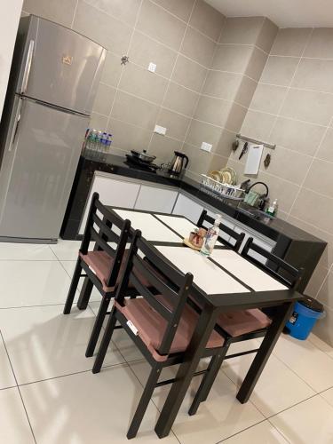 a kitchen with a table and chairs in a kitchen at Sunway City Onsen COSY HOME Tambun Ipoh in Ipoh