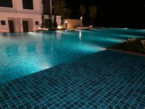 a swimming pool lit up at night at Sunway City Onsen COSY HOME Tambun Ipoh in Ipoh