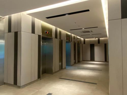 a hallway of an office building with a elevator at Sunway City Onsen COSY HOME Tambun Ipoh in Ipoh