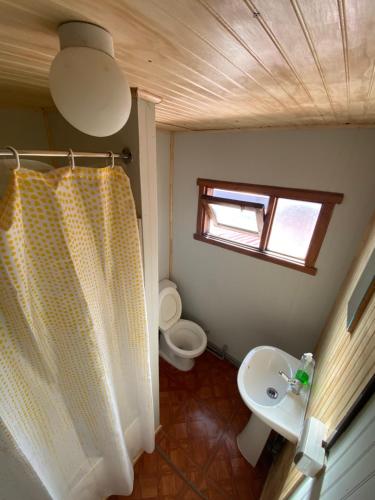 a small bathroom with a sink and a toilet at Hostería Futaleufu in Futaleufú