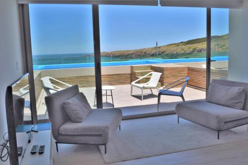 a living room with chairs and a view of the ocean at SYRAH Premium B2 - Piscina privada con vista al mar by depptö in Punta del Este