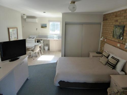 a bedroom with a bed and a living room and a kitchen at The Balnarring Motel in Balnarring
