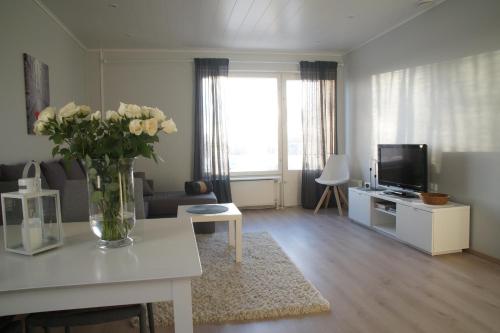 uma sala de estar com um vaso de flores sobre uma mesa em Stylish 2Room apartment in beautiful place, Free parking em Oulu