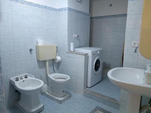 La salle de bains blanche est pourvue de toilettes et d'un lavabo. dans l'établissement Casa Bona Furtuna, à Catane