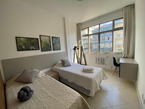 een kamer met 2 bedden en een raam bij Posto 9, Ipanema 2 quartos com suíte in Rio de Janeiro