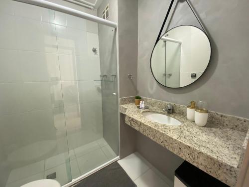 een badkamer met een douche, een wastafel en een spiegel bij Posto 9, Ipanema 2 quartos com suíte in Rio de Janeiro