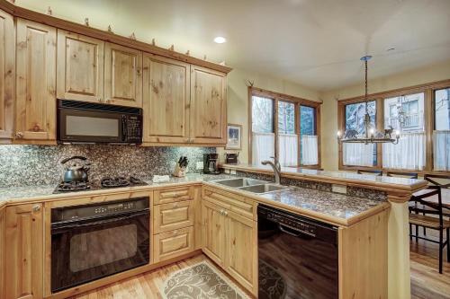 a kitchen with wooden cabinets and a sink and a microwave at The Perfect Large Family Retreat condo in Beaver Creek