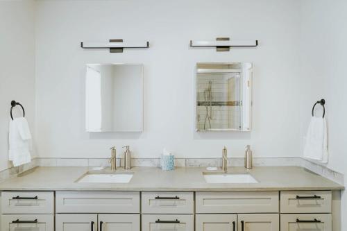 a white bathroom with two sinks and a mirror at The Circle Unit B in Bozeman