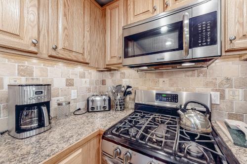 a kitchen with a stove and a microwave at Vermont's Finest - Brookhaven F4 in Ludlow