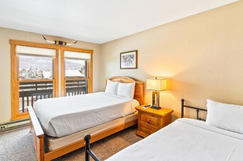 two beds in a room with a window at Lodge at Steamboat A309 in Steamboat Springs