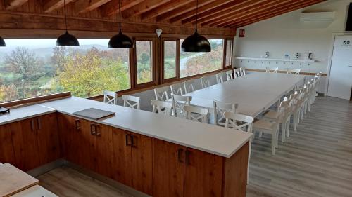 una gran sala de conferencias con una mesa larga y sillas en Casa Rural Ropino, en El Raso