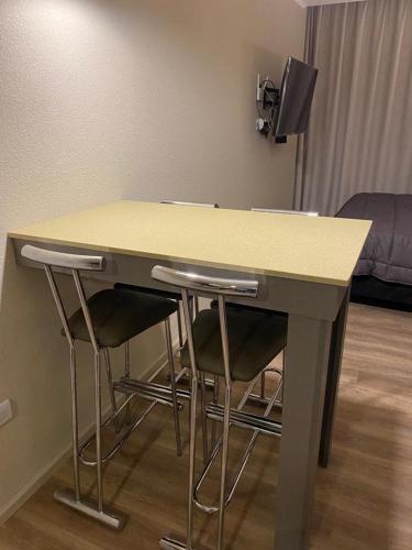 una mesa con cuatro taburetes debajo en una habitación en Necoplaya alquiler Necochea en Necochea