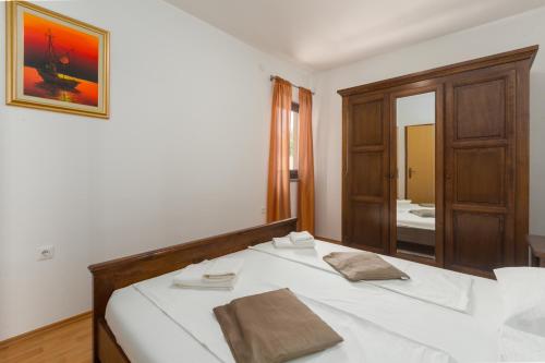 ein weißes Bett in einem Zimmer mit Spiegel in der Unterkunft Apartments in Porec - Istrien 43248 in Poreč