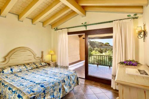 ein Schlafzimmer mit einem Bett und einem Balkon in der Unterkunft Apartment in Liscia di Vacca - Sardinien 43449 in Liscia di Vacca