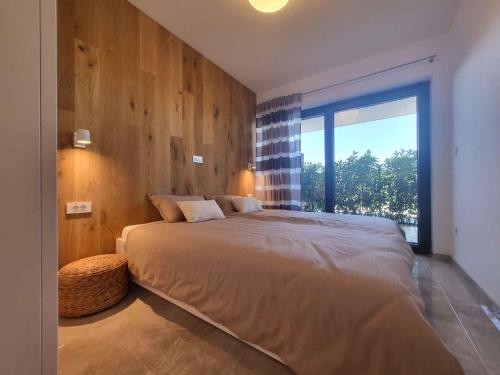 ein Schlafzimmer mit einem großen Bett und einem großen Fenster in der Unterkunft Apartment in Milcetici - Insel Krk 43321 in Sveti Anton