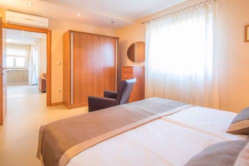 Pokój hotelowy z dużym łóżkiem i krzesłem w obiekcie Apartment in Malinska - Insel Krk 43327 w mieście Malinska