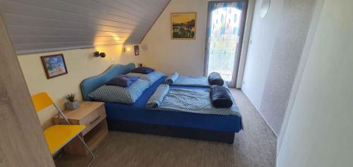 Un dormitorio con una cama azul y una ventana en Holiday home in Balatonmariafürdo 43399, en Balatonmáriafürdő