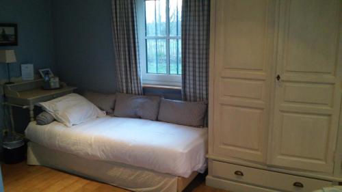 a bedroom with a bed and a window and a couch at Hostellerie au Coeur du Spinois in Rebecq-Rognon