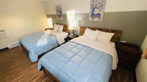 a room with two beds in a hotel room at Timberland Inn & Restaurant in Swan River