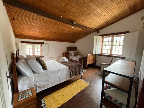 ein Schlafzimmer mit einem Bett und einer Holzdecke in der Unterkunft Sobrado da Prainha in Tiradentes