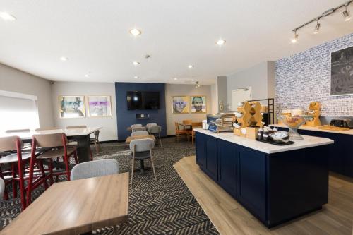 a kitchen and dining room with tables and chairs at AmericInn by Wyndham Duluth in Duluth