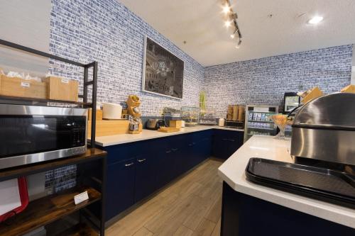 a large kitchen with blue cabinets and a microwave at AmericInn by Wyndham Duluth in Duluth
