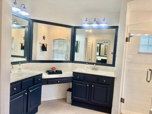 a bathroom with two sinks and two mirrors at Dreamy Family Pool House in Clermont