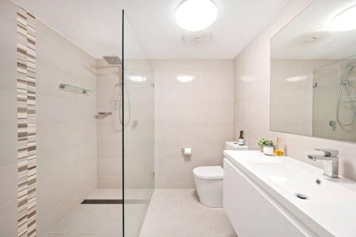 a bathroom with a shower and a toilet and a sink at The Crest in Shoal Bay