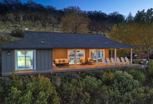 a house with a deck with chairs on it at Vineyard Setting With 180 Panoramic Lake Views in Lower Lake