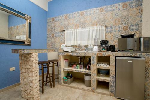 a kitchen with blue walls and a counter with a counter top at ALDEA JO-YAH in Tulum
