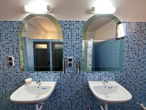 uma casa de banho com dois lavatórios e dois espelhos em Orca Surf House em Taghazout