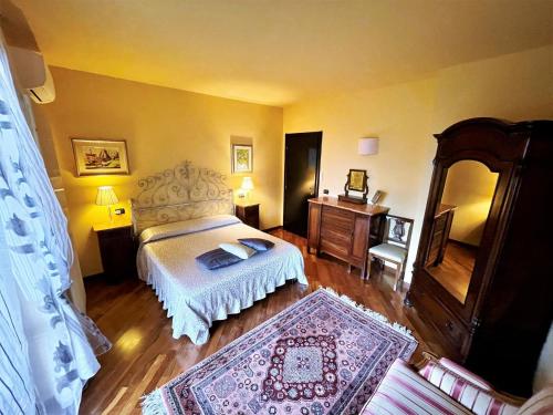 1 dormitorio con cama, tocador y espejo en Attractive villa in Marsciano Perugia with a pool, en Marsciano
