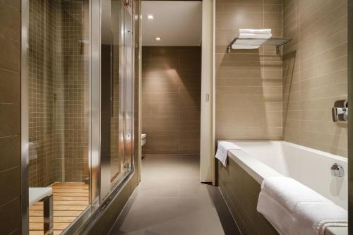 a bathroom with a bath tub and a shower at Park Hotel Almaty in Almaty