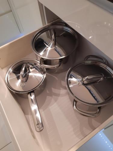 three chrome dishes sitting on top of a kitchen counter at Apartament Siedlce in Siedlce