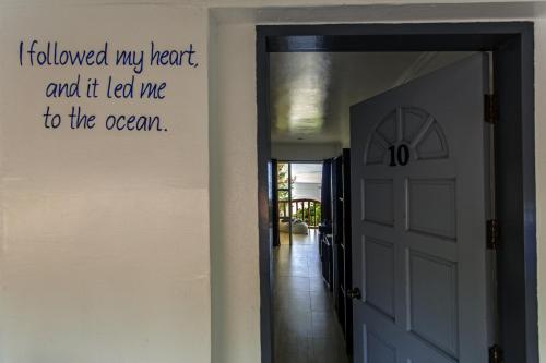 a hallway with a door with a sign on the wall at Ocean Vida Beach and Dive Resort in Daanbantayan