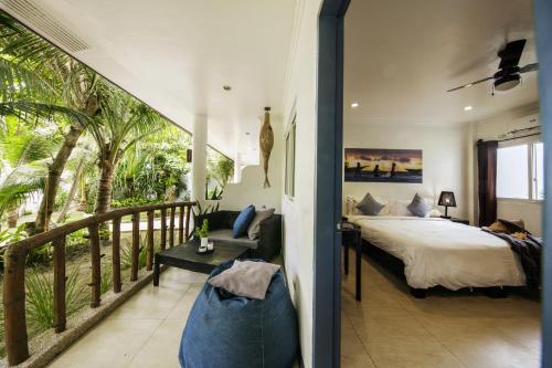 Ocean Vida Beach and Dive Resort في Daanbantayan: غرفة نوم بسرير وشرفة