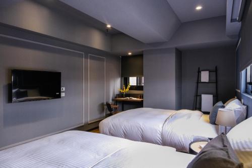 a bedroom with two beds and a flat screen tv at Giant Rich Hotel in Taipei