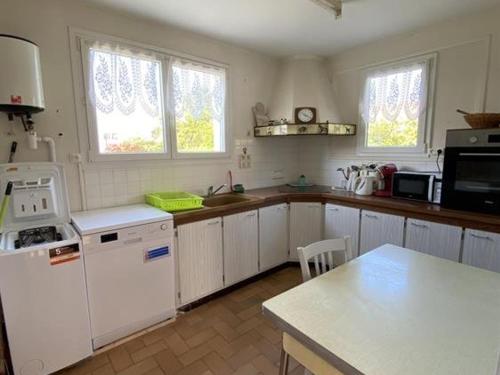 - une cuisine avec des appareils électroménagers blancs et un comptoir dans l'établissement Maison au cœur de La Brée-les-Bains - 6 couchages, jardin clos, proche plage, WiFi gratuit - FR-1-246A-156, à La Brée-les-Bains