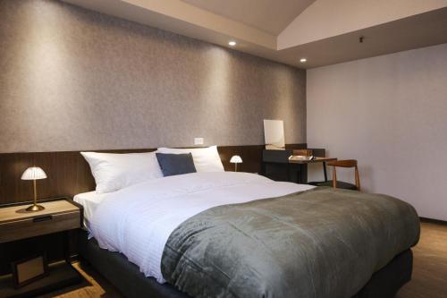 a bedroom with a large bed and a desk at Giant Rich Hotel in Taipei