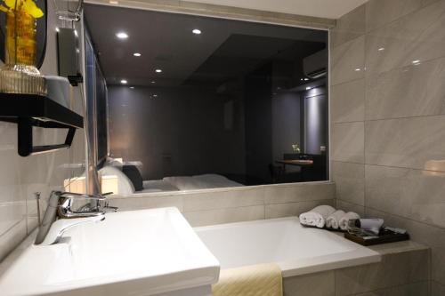 a bathroom with a sink and a large mirror at Giant Rich Hotel in Taipei