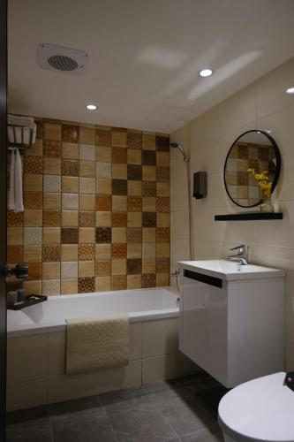 a bathroom with a tub and a toilet and a sink at Giant Rich Hotel in Taipei
