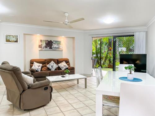 a living room with a couch and a table at Trinity Links Resort in Cairns